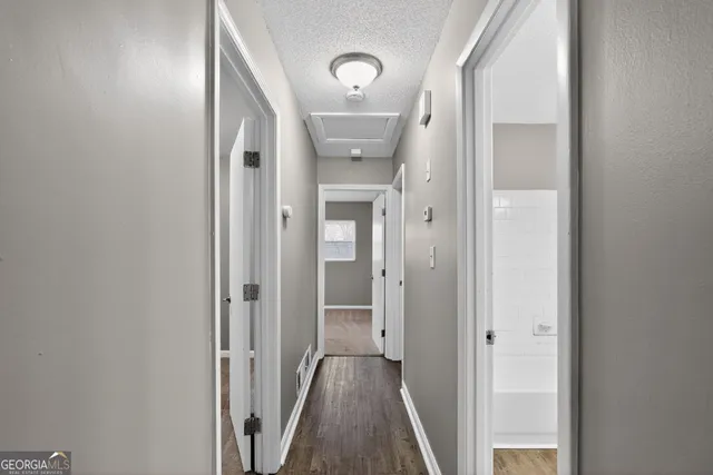 a view of a hallway with a livingroom and a bathroom with sink