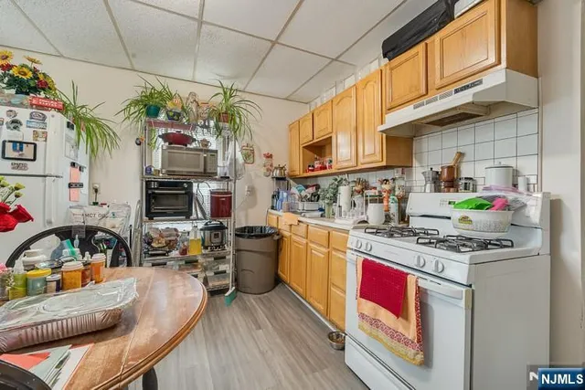 a kitchen with stainless steel appliances granite countertop a stove a sink dishwasher and cabinets with wooden floor