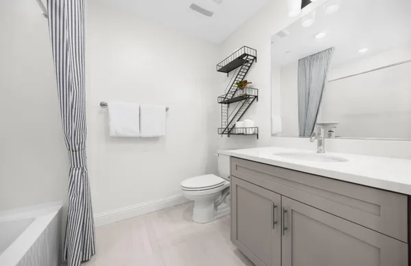 a bathroom with a sink a toilet and shower