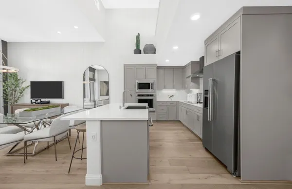 a kitchen with stainless steel appliances kitchen island granite countertop a sink refrigerator and microwave