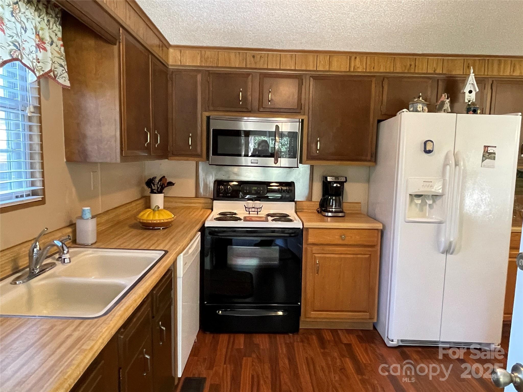 3403 Beaty Road Gastonia, NC 28056 - Photo 16 of 40 a kitchen with a sink a refrigerator a microwave and cabinets