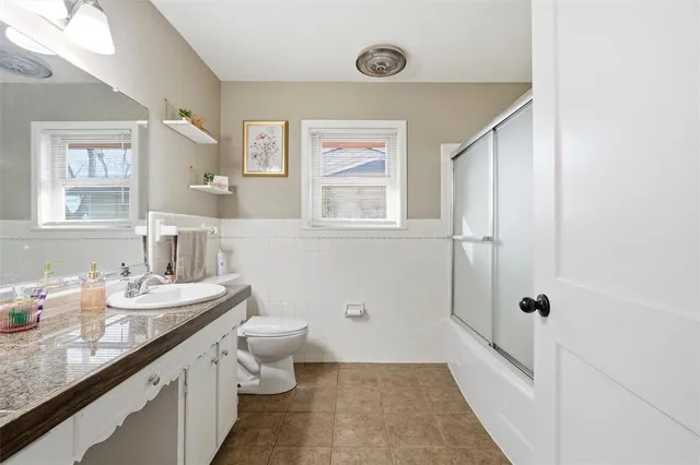 a bathroom with a granite countertop sink toilet and shower