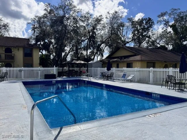 a view of backyard with swimming pool and furniture