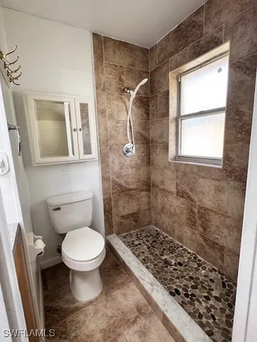 a bathroom with a toilet and a shower