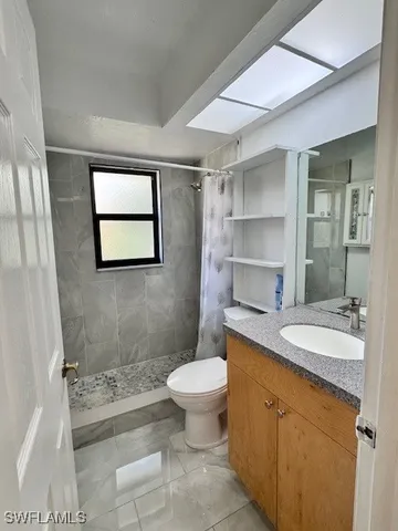 a bathroom with a granite countertop sink toilet and shower