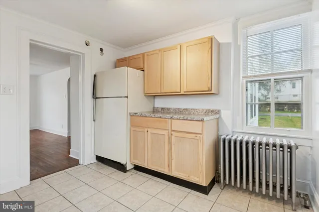 a kitchen with white cabinets and a refrigerator