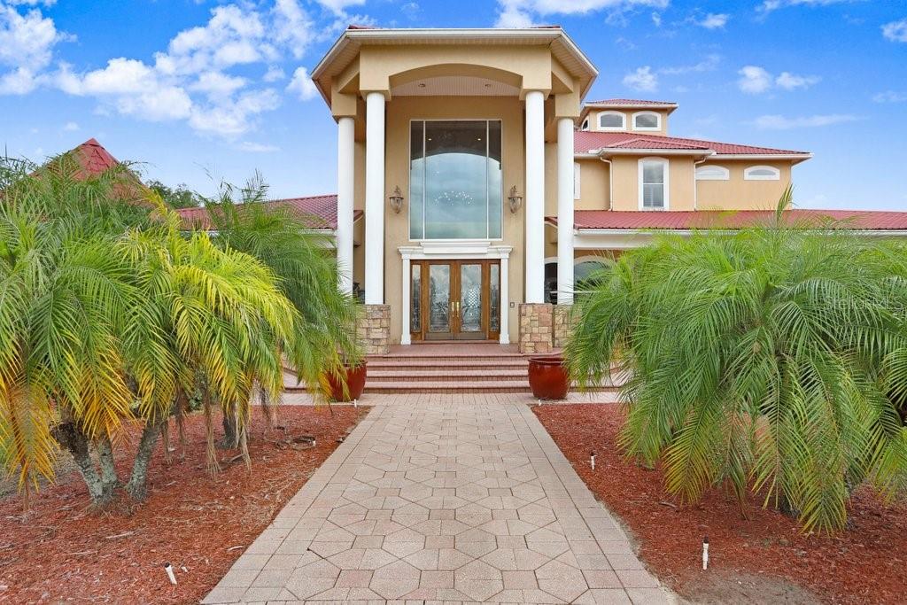 11715 Taylor Road Thonotosassa, FL 33592 - Photo 6 of 73 a view of a brick house with a large windows and plants