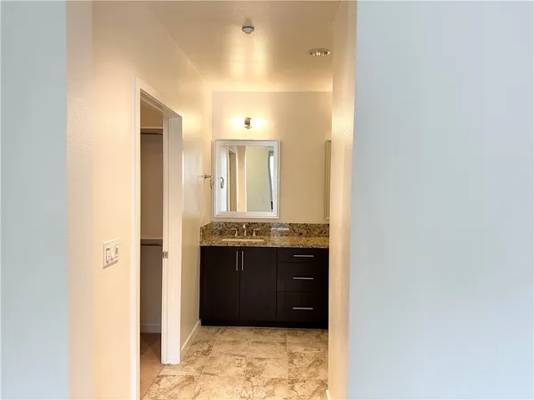 a bathroom with a granite countertop shower sink vanity and mirror