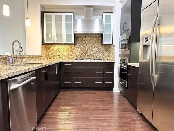 a kitchen with stainless steel appliances granite countertop a refrigerator and a sink