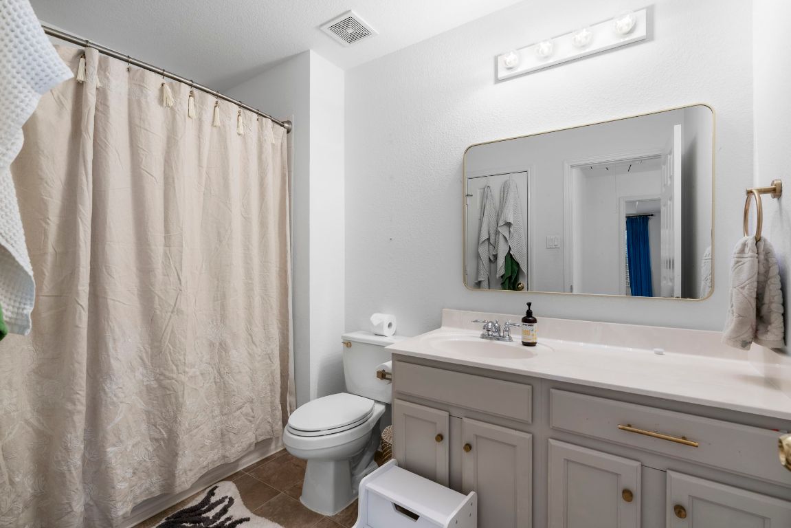 9201 Brodie Lane, Unit 2303 Austin, TX 78748 - Photo 21 of 26 a bathroom with a toilet a sink and a mirror