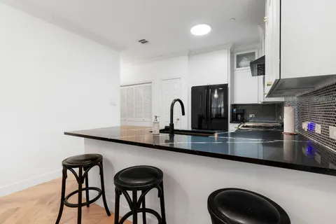 a kitchen with stainless steel appliances kitchen island a table and chairs in it