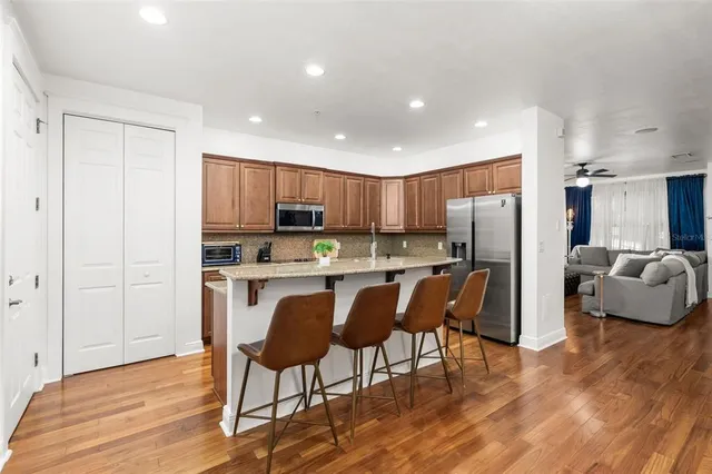 a kitchen with stainless steel appliances granite countertop a refrigerator and a stove top oven
