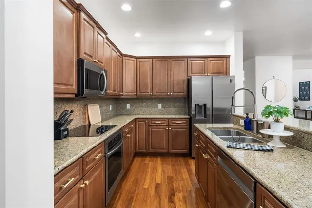 a kitchen with stainless steel appliances granite countertop a sink stove and cabinets