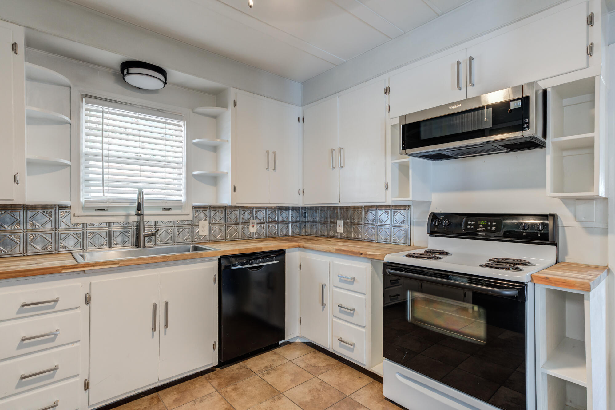 2629 24th Street Lubbock, TX 79410 - Photo 9 of 28 a kitchen with white cabinets stainless steel appliances and sink