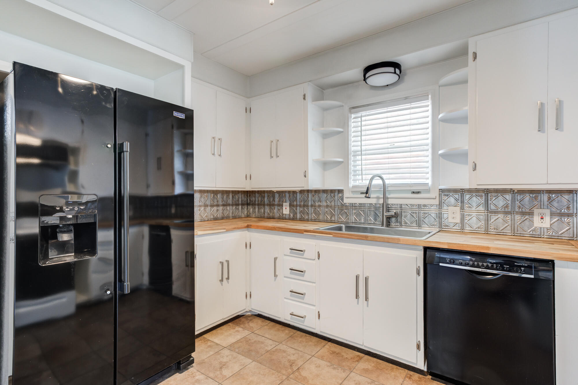 2629 24th Street Lubbock, TX 79410 - Photo 10 of 28 a kitchen with granite countertop white cabinets and stainless steel appliances