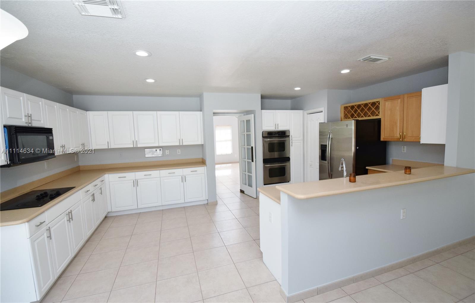 15381 Southwest 112th Terrace Miami, FL 33196 - Photo 13 of 43 a large kitchen with stainless steel appliances cabinets a sink and a stove