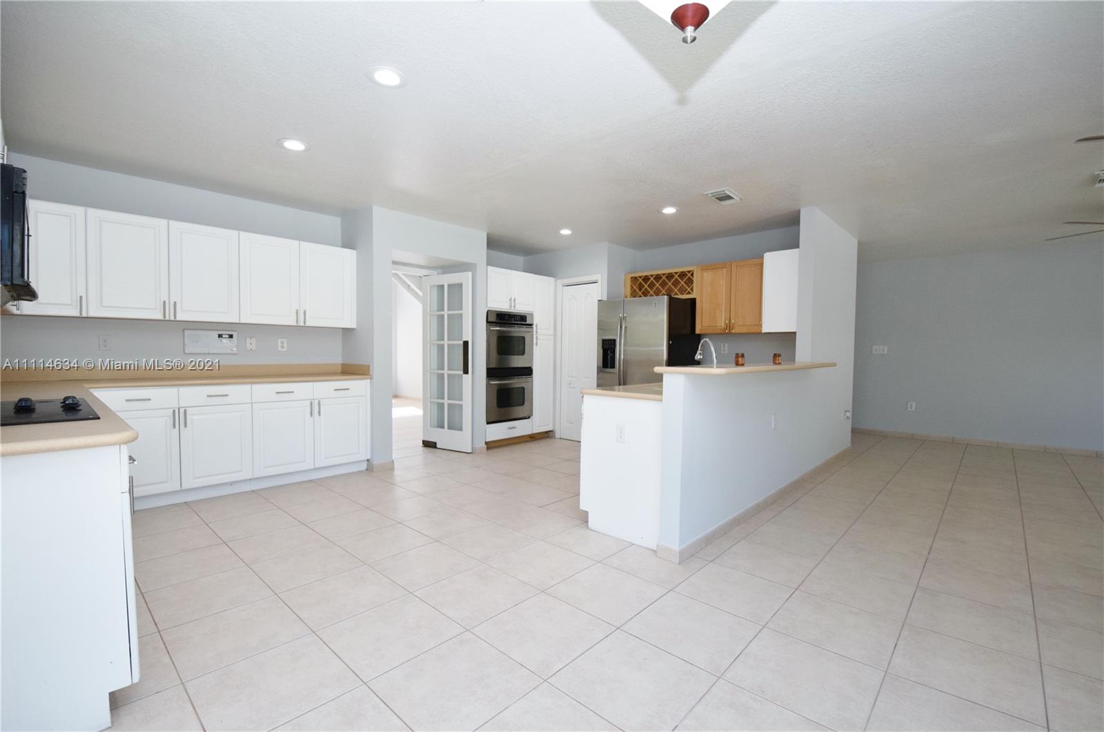 15381 Southwest 112th Terrace Miami, FL 33196 - Photo 14 of 43 a kitchen with stainless steel appliances kitchen island granite countertop a refrigerator sink and cabinets