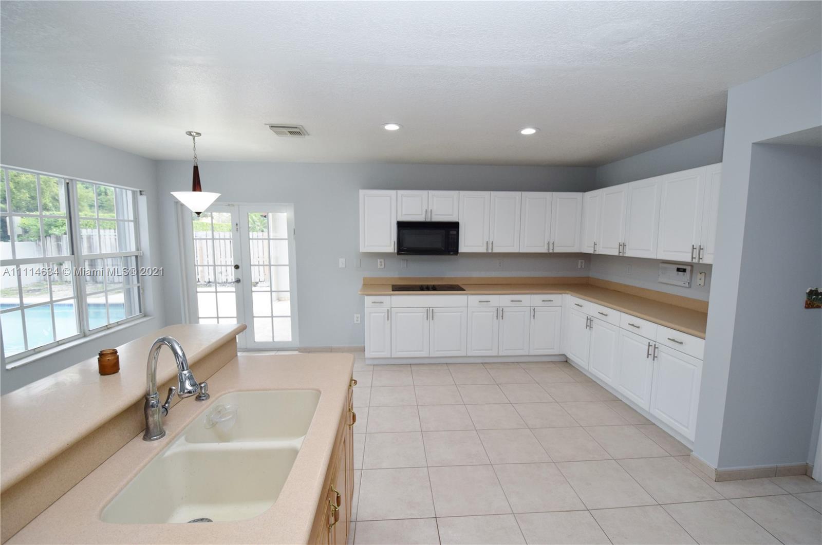15381 Southwest 112th Terrace Miami, FL 33196 - Photo 16 of 43 a large white kitchen with a large window