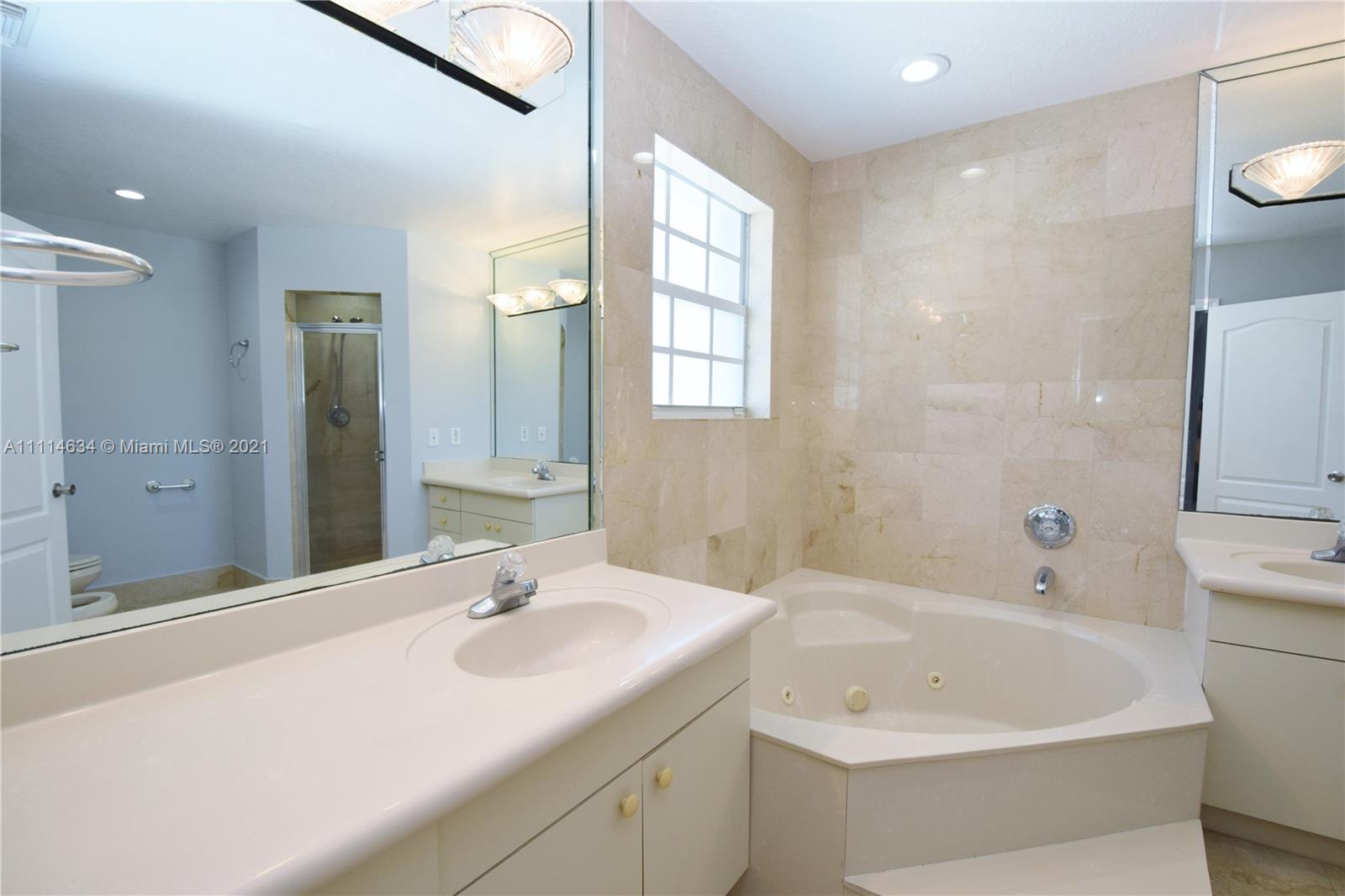 15381 Southwest 112th Terrace Miami, FL 33196 - Photo 19 of 43 a bathroom with a bathtub a sink and a large mirror