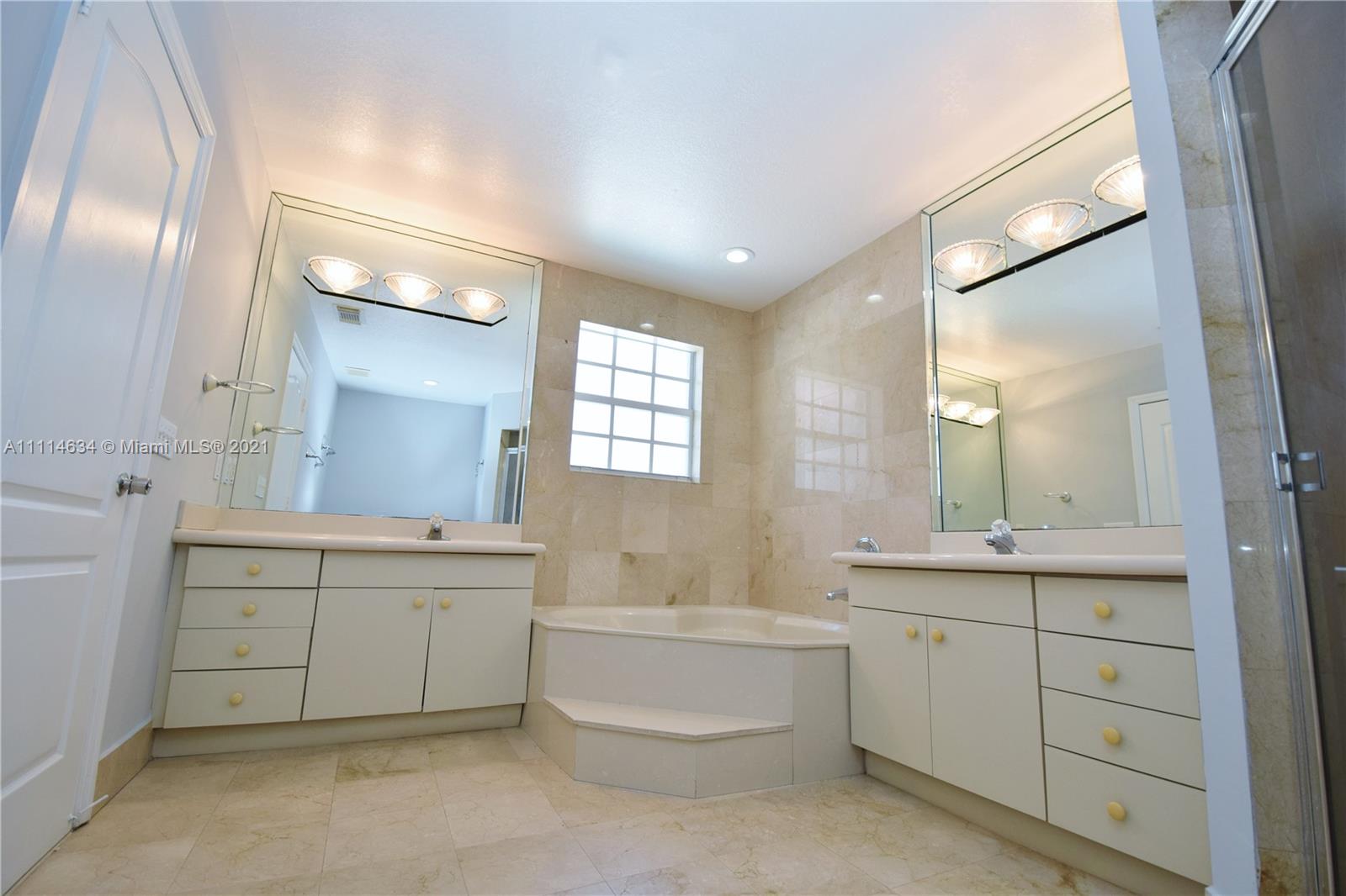 15381 Southwest 112th Terrace Miami, FL 33196 - Photo 21 of 43 a bathroom with a double vanity sink a large mirror and a bathtub