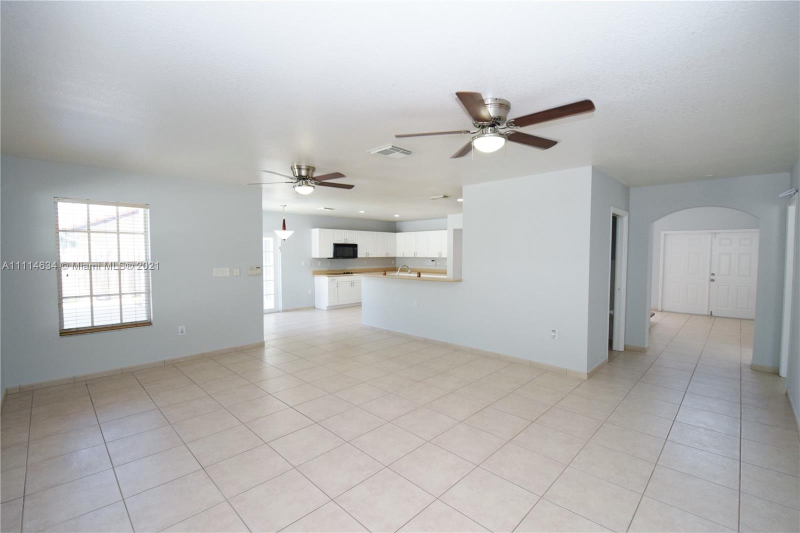 15381 Southwest 112th Terrace Miami, FL 33196 - Photo 29 of 43 an empty room with chandelier fan and windows