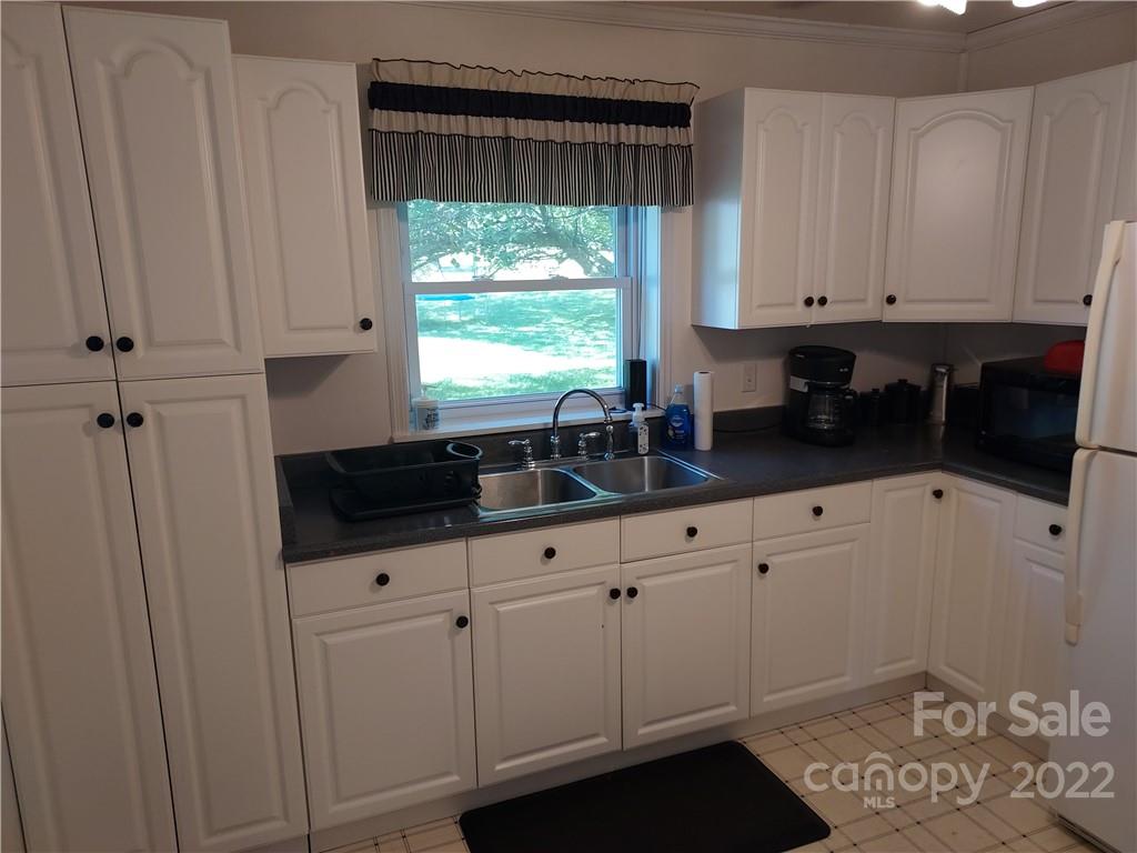 77 Floyd Blackwell Road Tryon, NC 28782 - Photo 8 of 32 a kitchen with white cabinets and sink