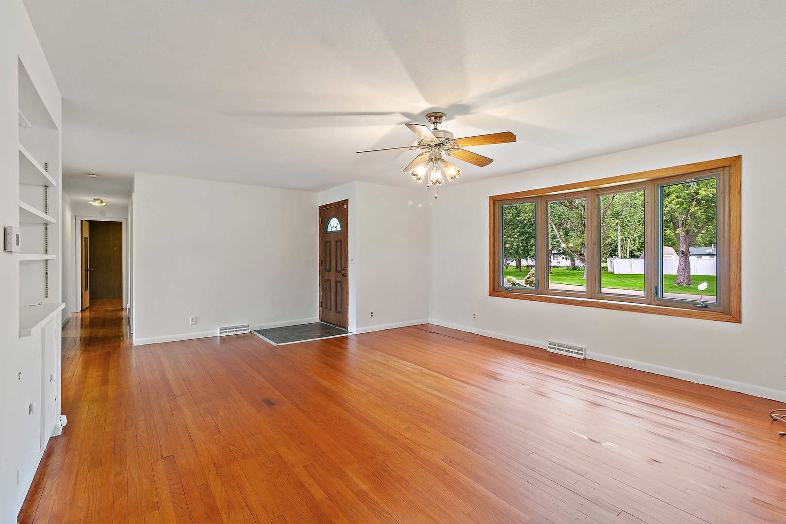 19 Durell Drive Kankakee, IL 60901 - Photo 2 of 25 an empty room with wooden floor chandelier fan and windows