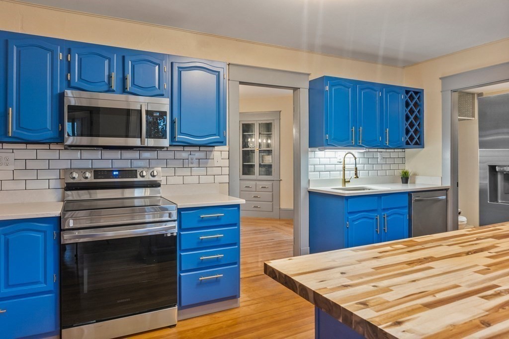 2191 Main Street Three Rivers, MA 01080 - Photo 12 of 42 a kitchen with stainless steel appliances granite countertop wooden cabinets stove top oven and sink