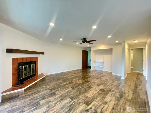 a view of an empty room with a fireplace and a window