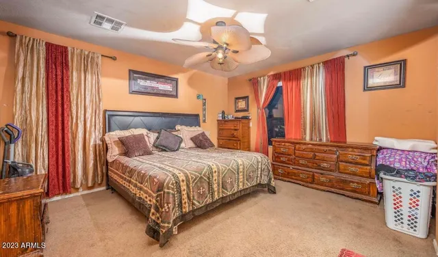 a spacious bedroom with a bed and a chandelier