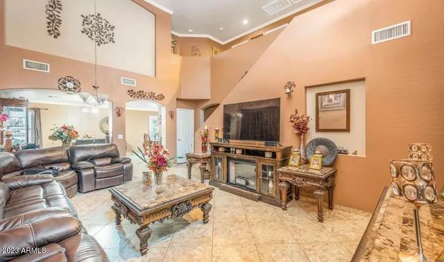 a living room with furniture a flat screen tv and kitchen view