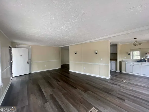 a view of empty room with wooden floor