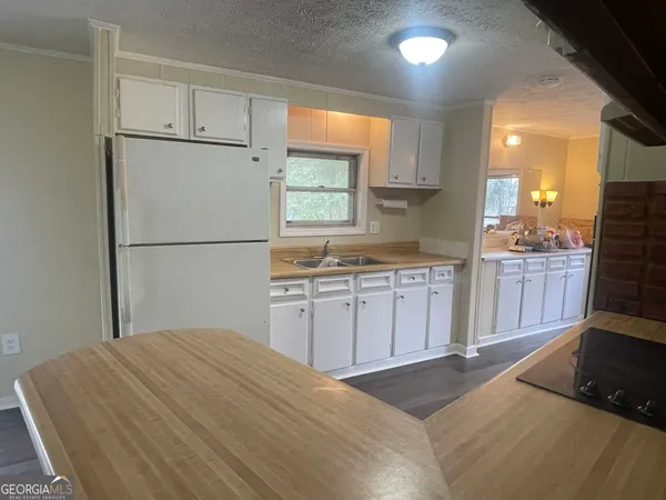 a kitchen with a sink a stove a refrigerator and cabinets