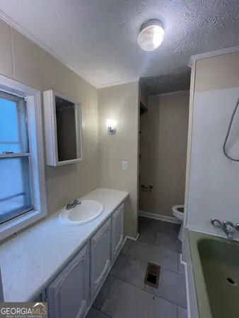 a bathroom with a double vanity sink and mirror with bathtub