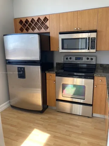 a kitchen with granite countertop a stove and a microwave oven