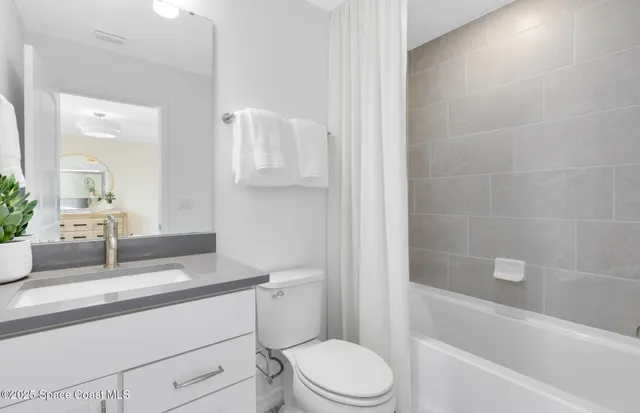 a bathroom with a sink a toilet a mirror and shower