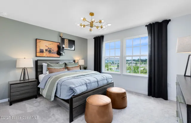 a bedroom with bed and a large window