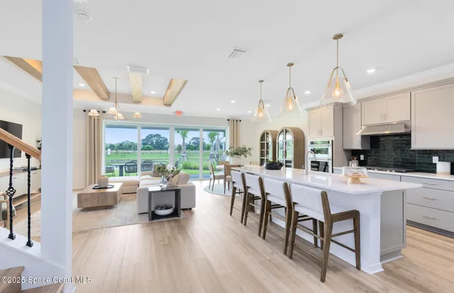 a large white kitchen with a large window and stainless steel appliances