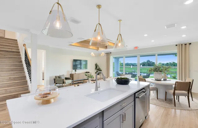 a kitchen with a sink dining table and chairs