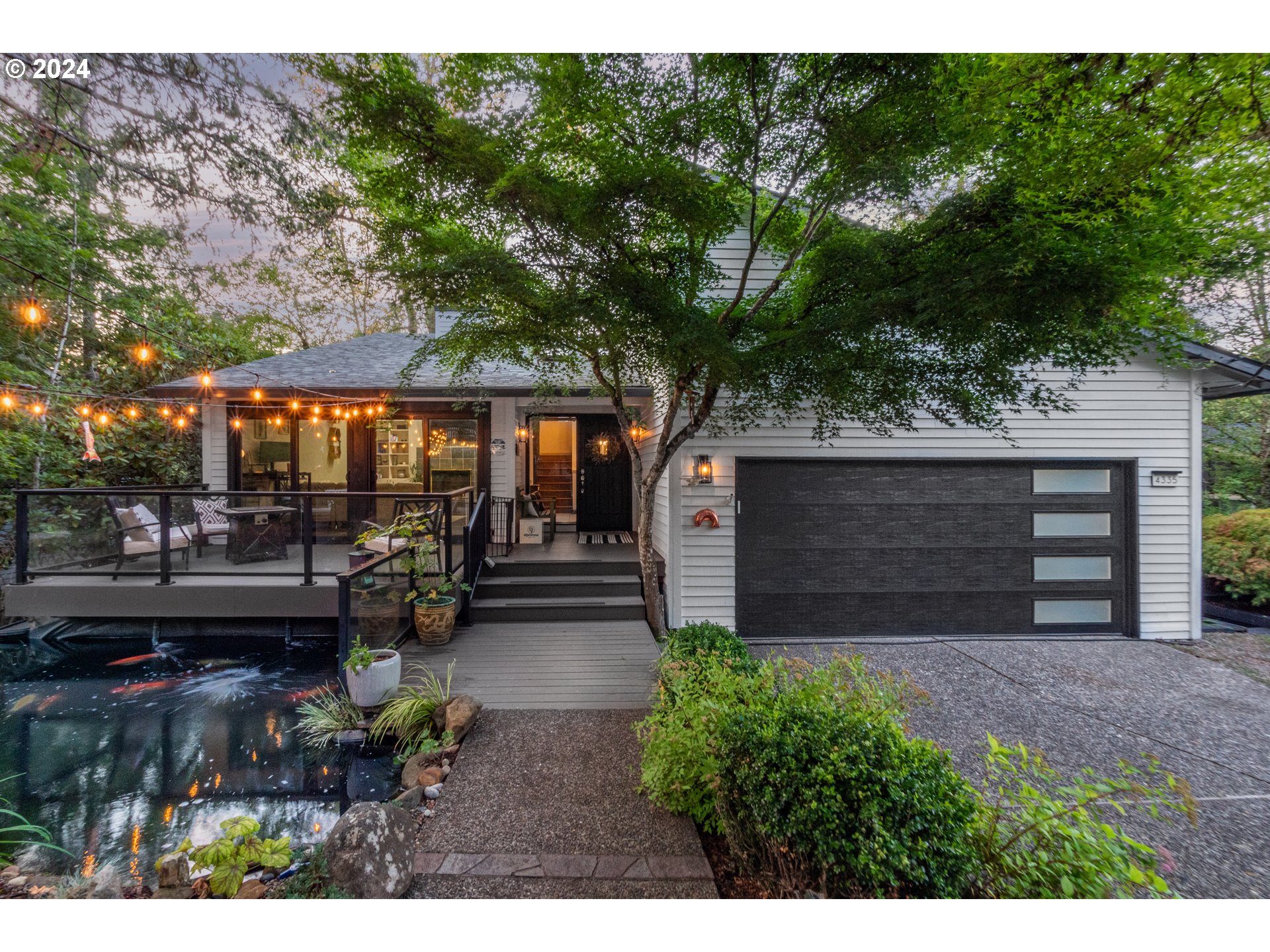 a view of a backyard with potted plants and a large tree