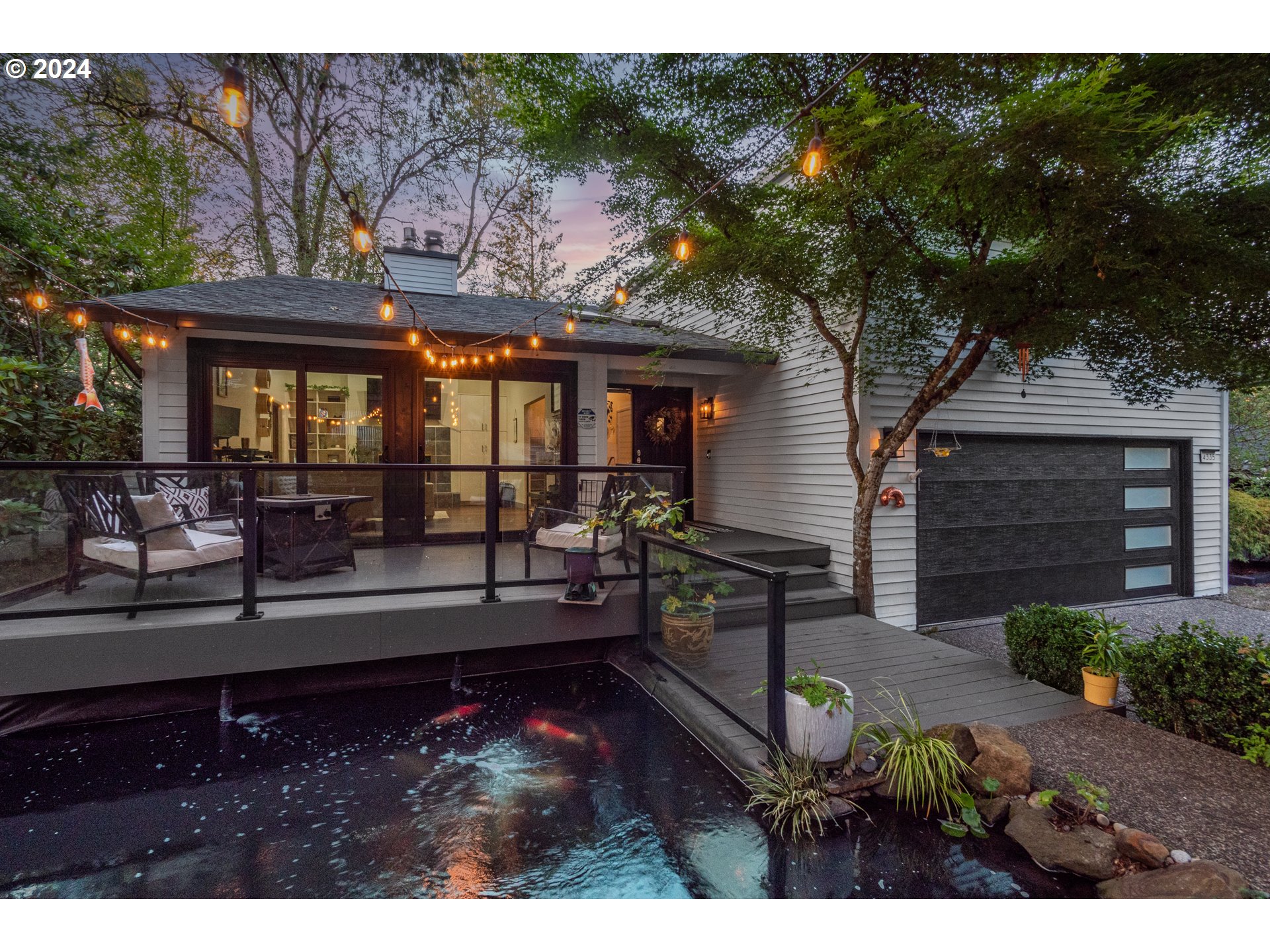 4335 Southwest Cullen Boulevard Portland, OR 97221 - Photo 2 of 46 a view of a house with floor to ceiling windows and a couple of fire pit
