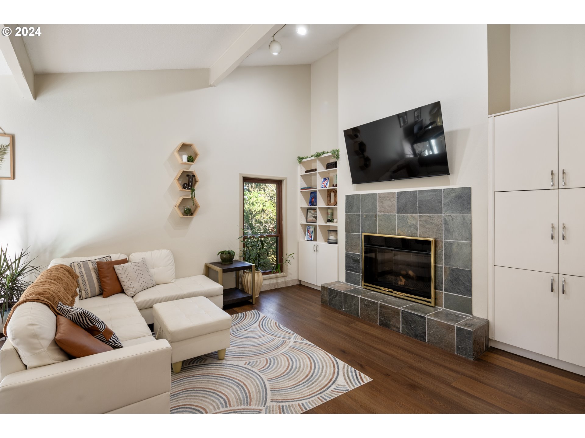 4335 Southwest Cullen Boulevard Portland, OR 97221 - Photo 5 of 46 a living room with furniture a flat screen tv and a fireplace