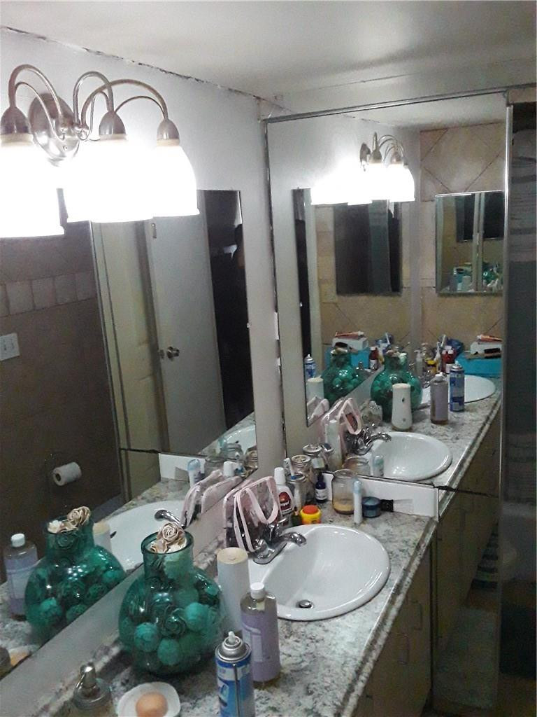 4222 Inverrary Boulevard, Unit 4610 Lauderhill, FL 33319 - Photo 16 of 32 a bathroom with a granite countertop sink a mirror and shower