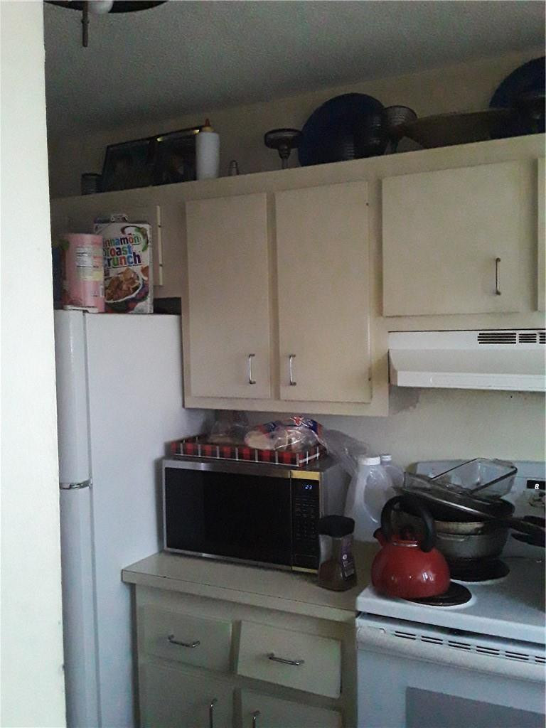 4222 Inverrary Boulevard, Unit 4610 Lauderhill, FL 33319 - Photo 17 of 32 a kitchen with a stove and cabinets