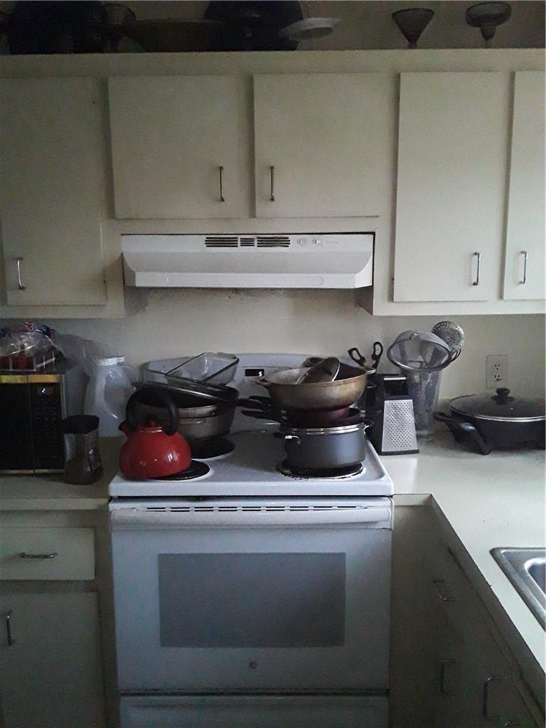 4222 Inverrary Boulevard, Unit 4610 Lauderhill, FL 33319 - Photo 19 of 32 a kitchen with a stove and cabinets