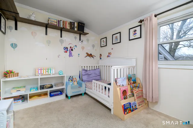 a bedroom with baby toys and hanging shelf
