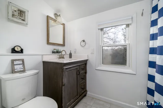 a bathroom with a toilet sink vanity and mirror