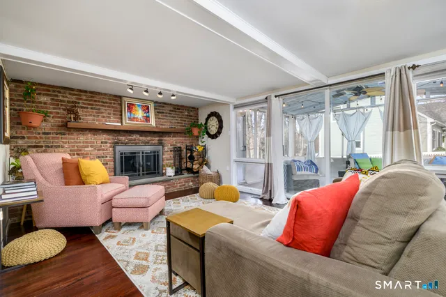 a living room with furniture fireplace and a large window