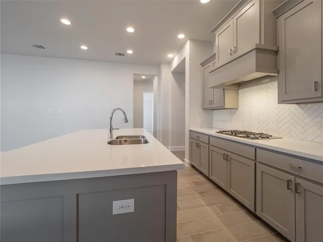 a kitchen with a sink a stove and cabinets