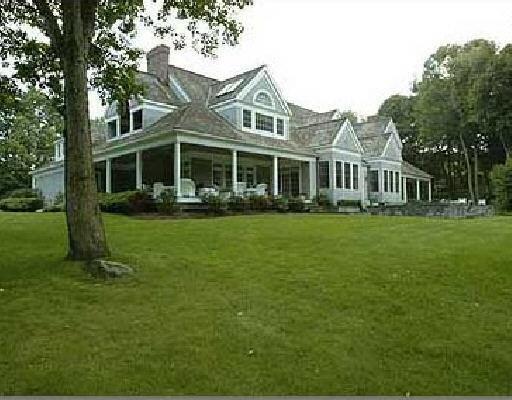 a front view of a house with a garden and trees
